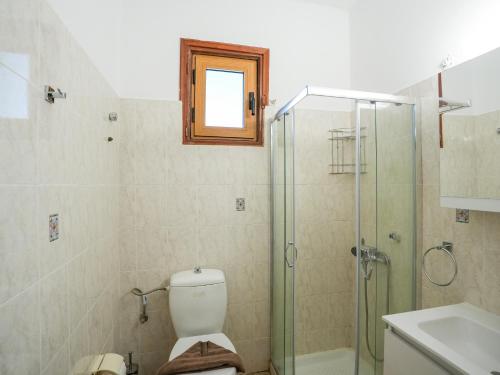 a bathroom with a shower and a toilet and a sink at Theodora Suite by Pegasus in Kardamaina