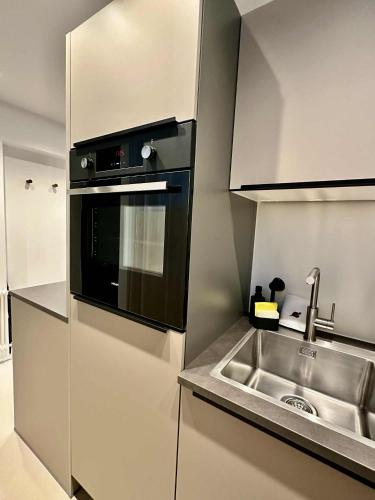 a kitchen with a sink and a microwave at Das Alpenzeit Loft mit Balkon und Grimmingblick in Bad Mitterndorf