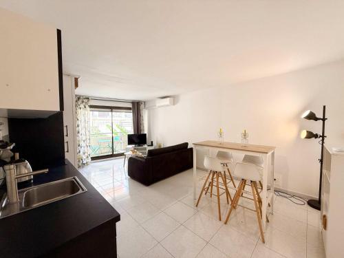 une cuisine et un salon avec une table et un canapé dans l'établissement B065 Appartement calme proche centre garage, à Cannes