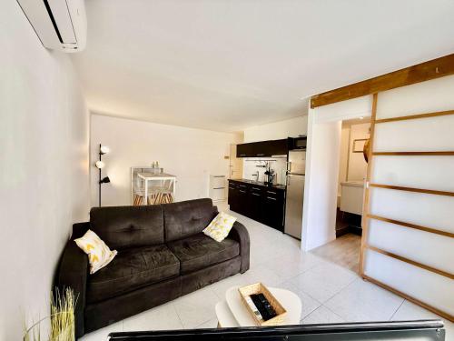 un salon avec un canapé et une cuisine dans l'établissement B065 Appartement calme proche centre garage, à Cannes
