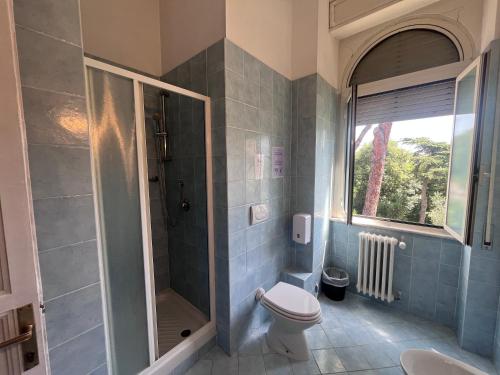 a bathroom with a shower and a toilet and a window at Green Park San Pancrazio in Rome