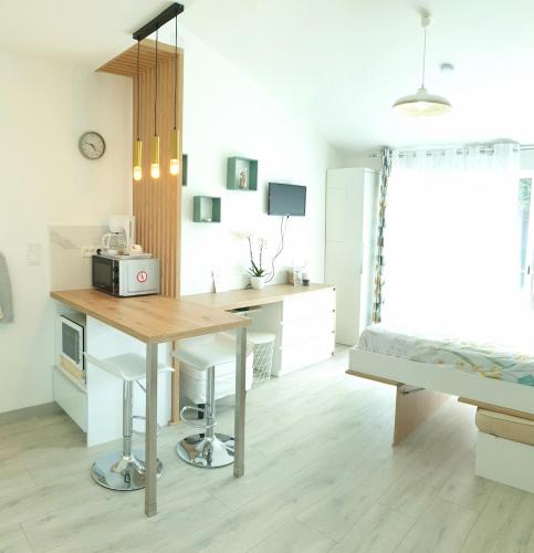 une cuisine avec une table et un four micro-ondes. dans l'établissement Kylian's Dream, Studio 3 étoiles 5 mn des plages, à Pérols