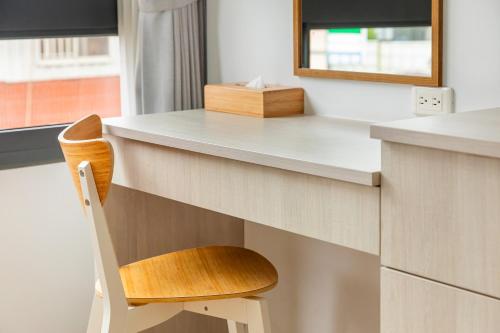 a wooden chair sitting at a desk with a mirror at Kapamumu b&b in Yuchi