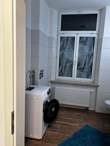 baño con lavadora y ventana en FeWo Vermietung Plauen, en Plauen