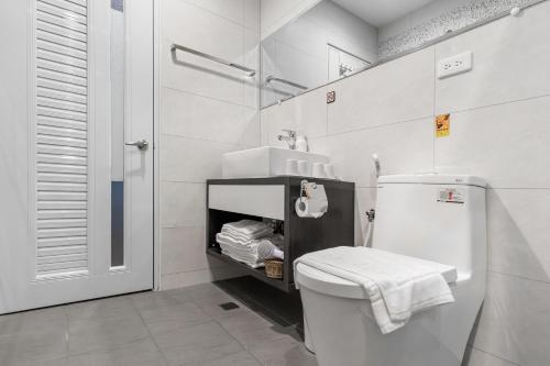 a white bathroom with a toilet and a sink at Kapamumu b&b in Yuchi