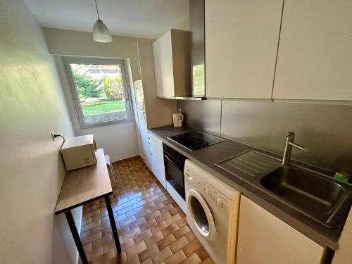une cuisine avec un évier et une machine à laver dans l'établissement Apparemment 2P centre Nice, à Nice