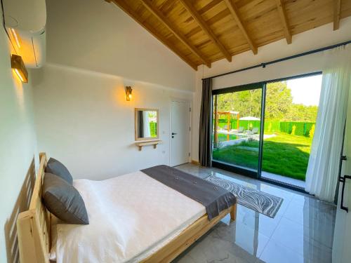 una camera da letto con un letto e una grande finestra di Villaderyadeniz a Kızılyaka