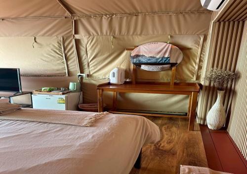 a bedroom with a bed and a table with a mirror at Taara Montana Resort in Ban Huai Khai