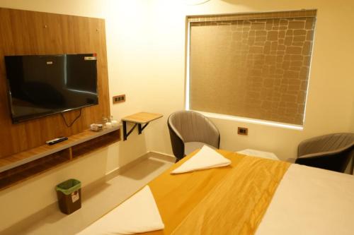 a conference room with a table and a television at Harika Guest Inn in Visakhapatnam