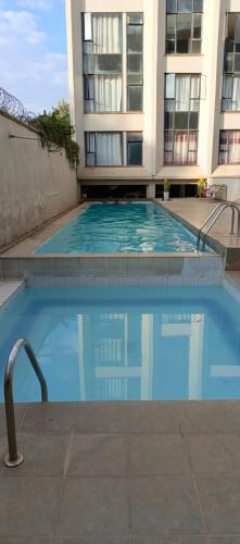 a large swimming pool in front of a building at Home Away in Ongata Rongai 