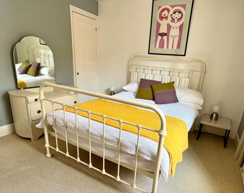 a bedroom with a white bed and a mirror at Stylish Victorian Cottage, 2mins from Whitstable Harbour & Shops in Whitstable