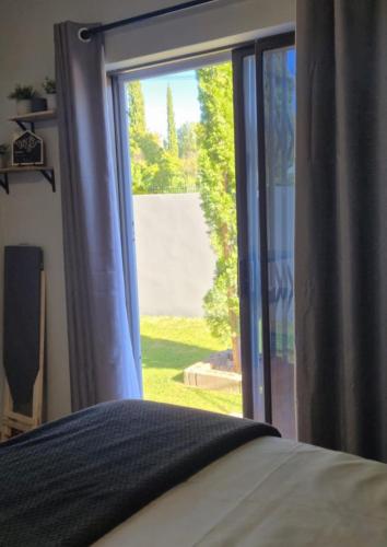 a bedroom with a window looking out at a yard at Amper Daar in Beaufort West