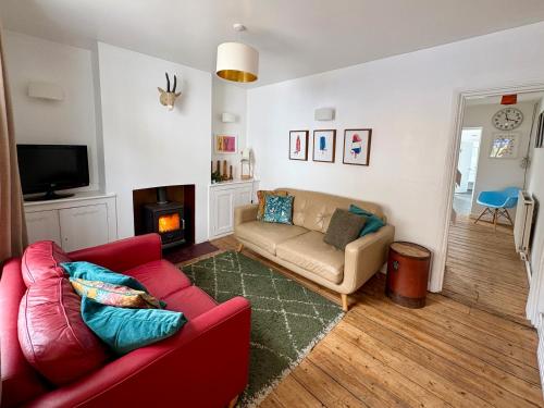 a living room with a couch and a tv at Stylish Victorian Cottage, 2mins from Whitstable Harbour & Shops in Whitstable