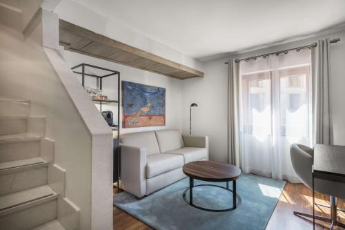 a living room with a white couch and a table at NH Collection Salamanca Palacio de Castellanos in Salamanca