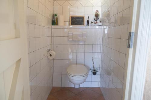 une salle de bain avec toilettes et un mur carrelé dans l'établissement Apartment Noorderloft, à Hornhuizen