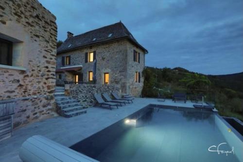 a house with a swimming pool in front of a building at Aubié superbe propriété pour 20 avec piscine in Latouille-Lentillac