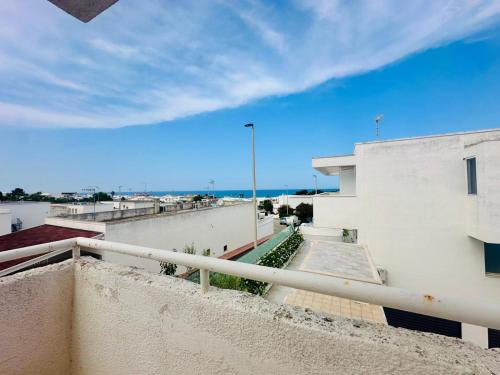 a balcony of a building with the ocean in the background at Giardino dei Trulli - Villa al Mare in Faccia di Trippa