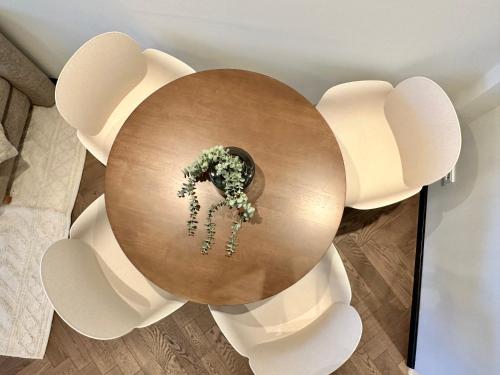 a round wooden table with a bouquet of flowers on it at Das Alpenzeit Loft mit Balkon und Grimmingblick in Bad Mitterndorf