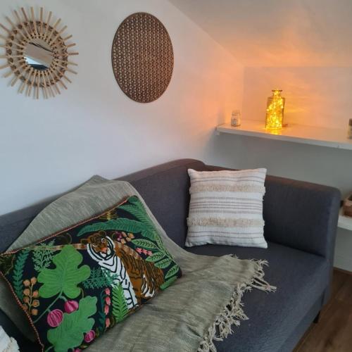 un canapé avec des coussins dessus dans un salon dans l'établissement Mercadial au coeur de Saint-Céré, à Saint-Céré