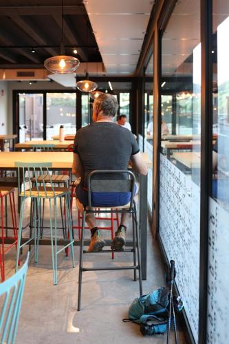 a man sitting in a chair at a restaurant at KY Mountain Hostel Arinsal in Arinsal