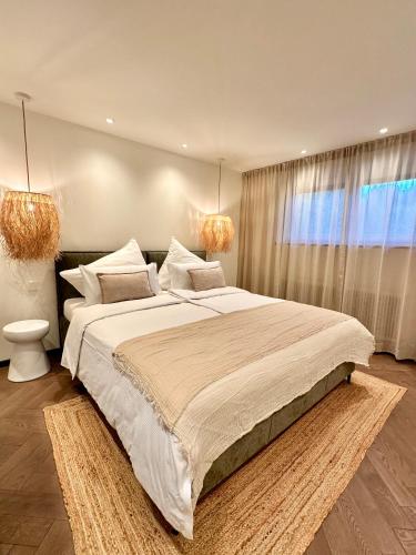 a bedroom with a large bed and a window at Das Alpenzeit Loft mit Balkon und Grimmingblick in Bad Mitterndorf