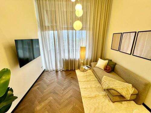 a living room with a couch and a large window at Das Alpenzeit Loft mit Balkon und Grimmingblick in Bad Mitterndorf