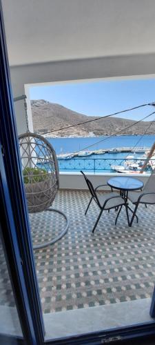 a balcony with a table and a chair at Kalliopis Rooms in Katapola