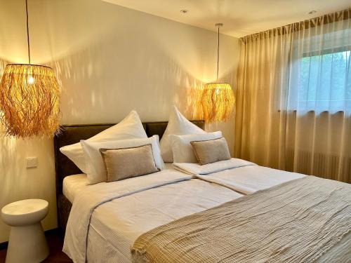 a bedroom with a bed with white sheets and pillows at Das Alpenzeit Loft mit Balkon und Grimmingblick in Bad Mitterndorf