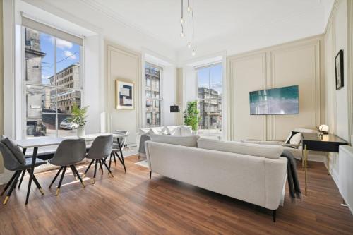 a living room with a couch and a table and chairs at (G1) Elegant 2 bed Blythswood Apartment in Glasgow
