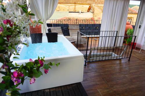 a hot tub on a balcony with flowers at Teatro Massimo Terrace relax suite in Palermo