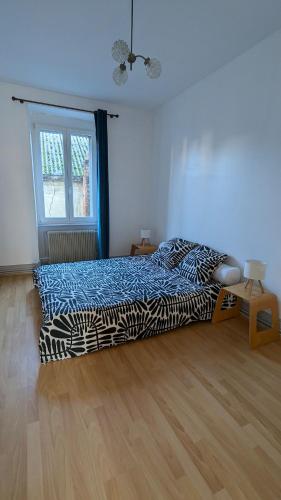 une chambre avec un lit et un parquet dans l'établissement 75m2 - 2min centre piéton & 10 min de la gare, à Mulhouse