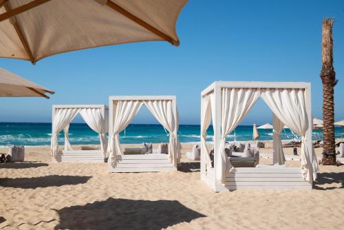 a wedding ceremony on the beach with umbrellas at Cleopatra Sidi Heneish in Marsa Matruh