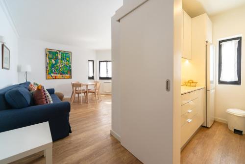 a living room with a blue couch and a kitchen at Cascais Bay in Cascais