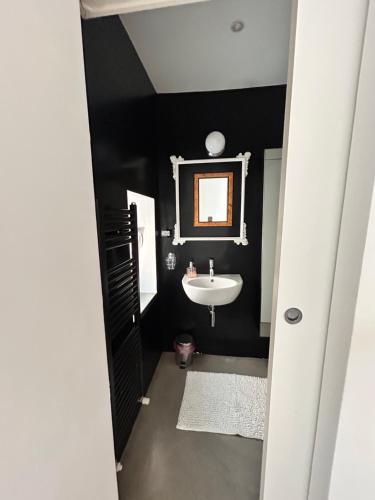 a black bathroom with a sink and a mirror at Bon Bon XX Settembre in Asti