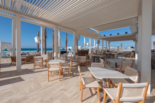 a restaurant on the beach with tables and chairs at Cleopatra Sidi Heneish in Marsa Matruh