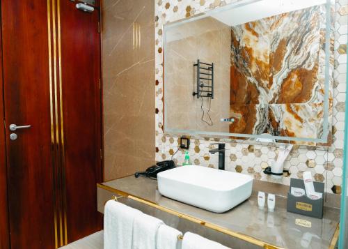 une salle de bains avec un lavabo blanc et un miroir dans l'établissement Gerwill Hotel, à Dodoma