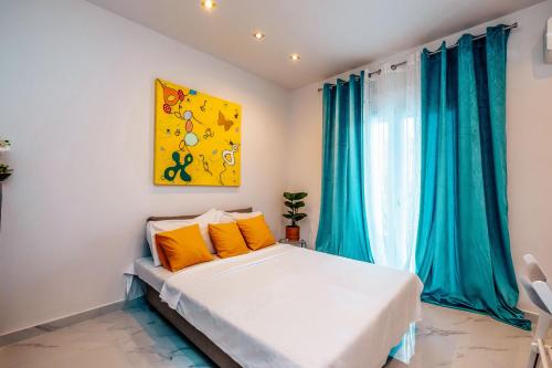 a bedroom with a large bed with blue curtains at Studio Filipos in Kallithea Halkidikis