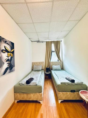 zwei Einzelbetten in einem Zimmer mit Fenster in der Unterkunft Stylish 2BR Shared Apt, Sleeps 6 Direct City Access in Wien
