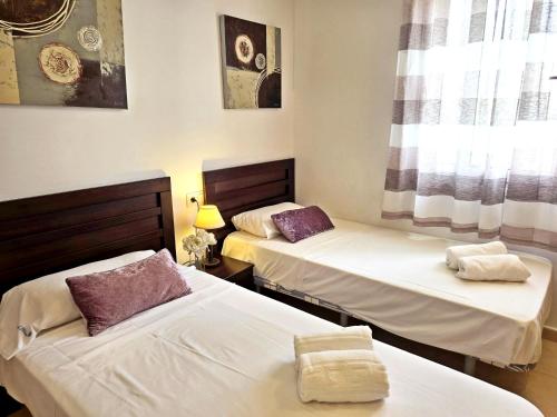 a room with two beds and a window at Villa Azul Mar Menor by Rentalole in Las Casicas