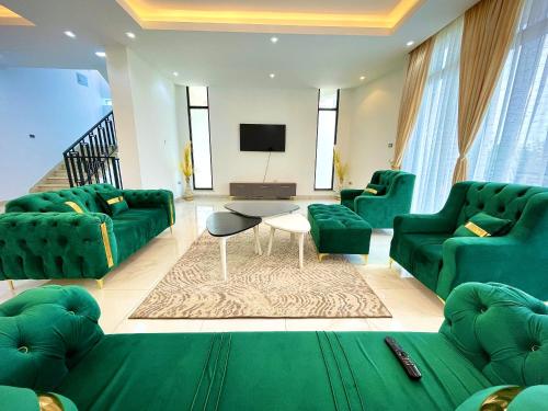 un soggiorno con divani verdi e TV di Luxurious & Spacious Mega Home! ad Addis Abeba