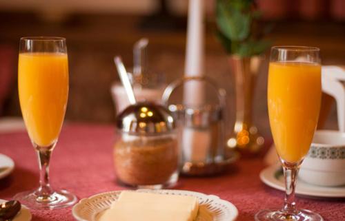 two glasses of orange juice on a table with cheese at Haus Petersmann in Ramsau am Dachstein