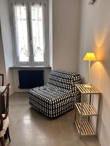 a living room with a black and white couch and a lamp at Bon Bon XX Settembre in Asti