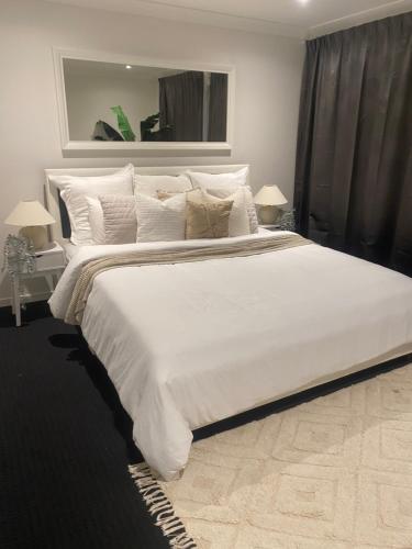 a large white bed with white pillows in a bedroom at Bayside Retreat in Newport