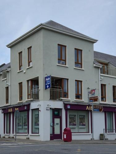 a large white building on the corner of a street at Teachín an tSrutháin in Galway