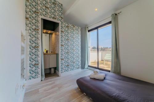 une chambre avec un grand lit et une grande fenêtre dans l'établissement Villa de Caractère Piscine Cosy & Calme, à Tassin-la-Demi-Lune