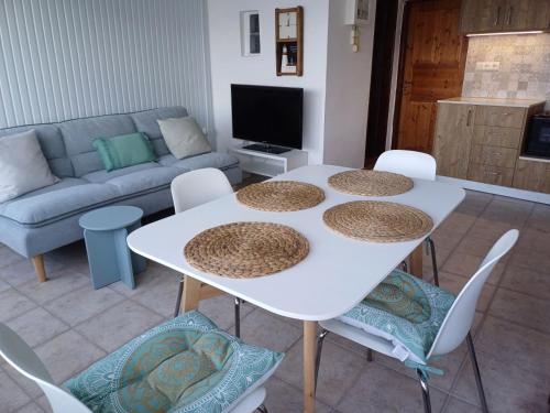 a living room with a white table and chairs at Azure Horizon in Mochlos
