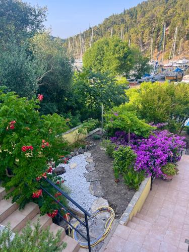 a bench in a garden with flowers and plants at Apartments & Rooms Formenti in Skradin
