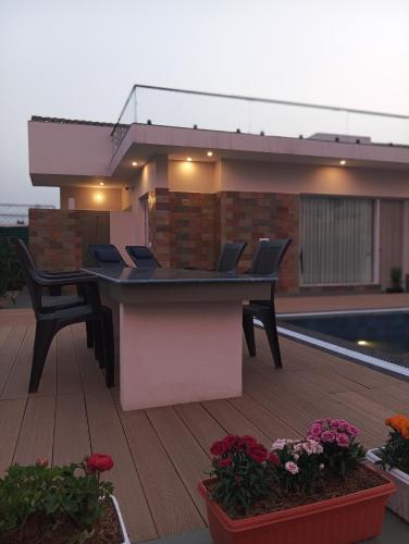 a patio with a table and chairs on a deck at Tattvam Farm Stayz & Swimming Pool in Kālka