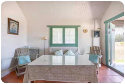 een eetkamer met een glazen tafel en stoelen bij La Cabaña de Doñana in El Rocío