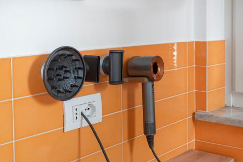 a black fan plugged into a wall in a bathroom at Palazzo Tasso in Sorrento